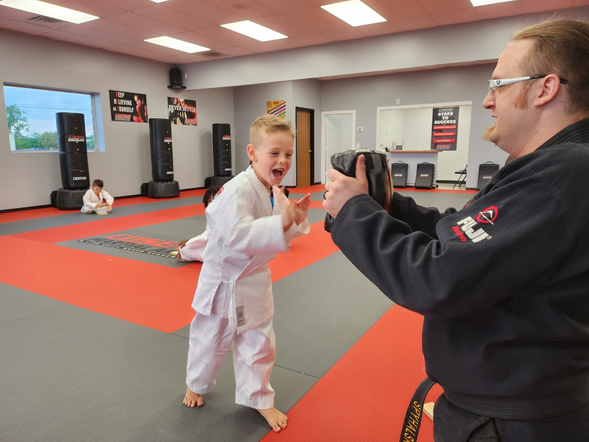 A child enjoying a beginner martial arts lesson with an instructor