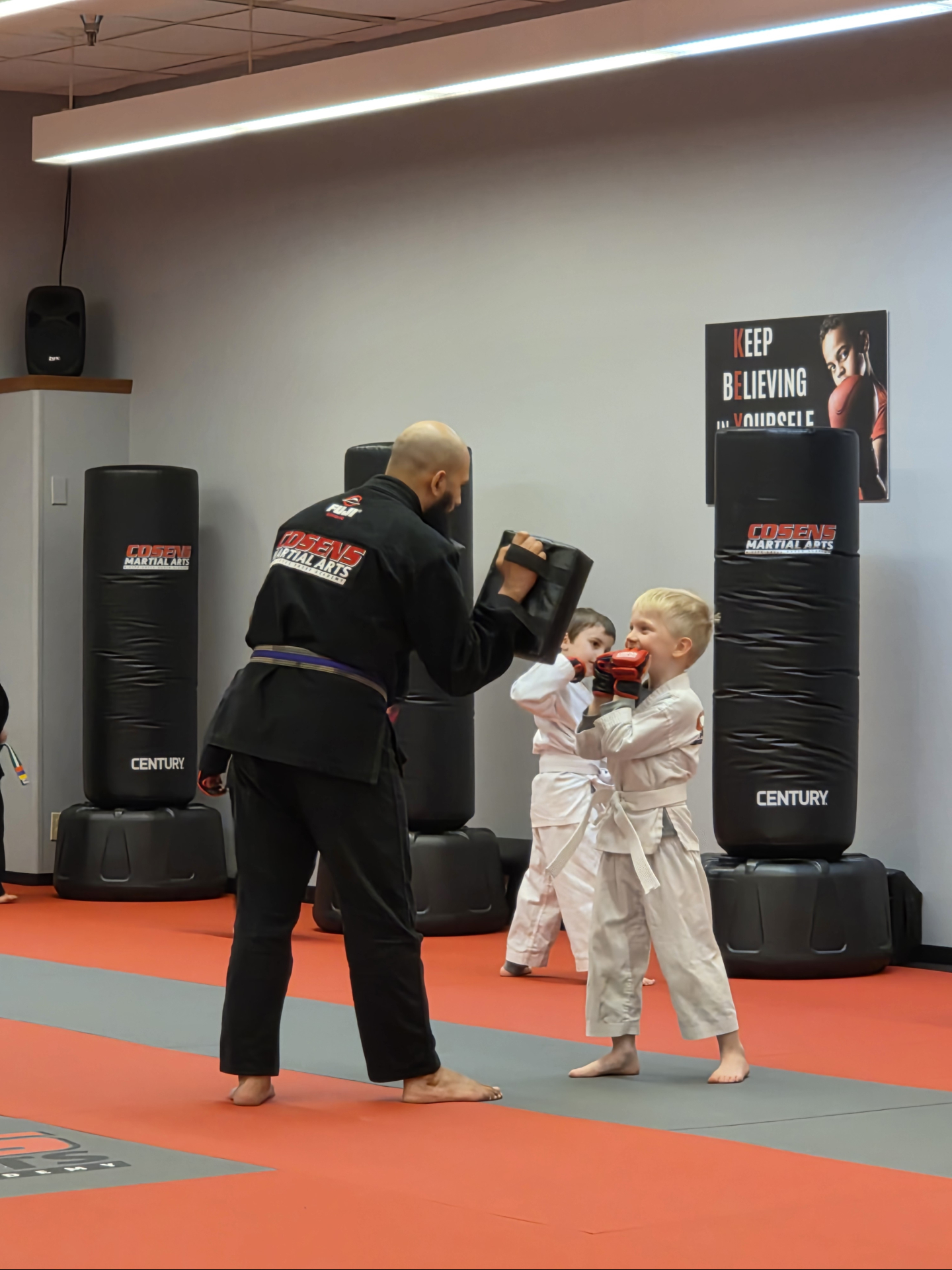Instructor helping a young child practice martial arts